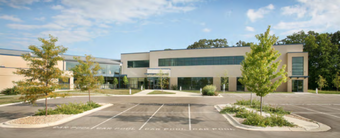 Modern commercial office building exterior with landscaped parking lot